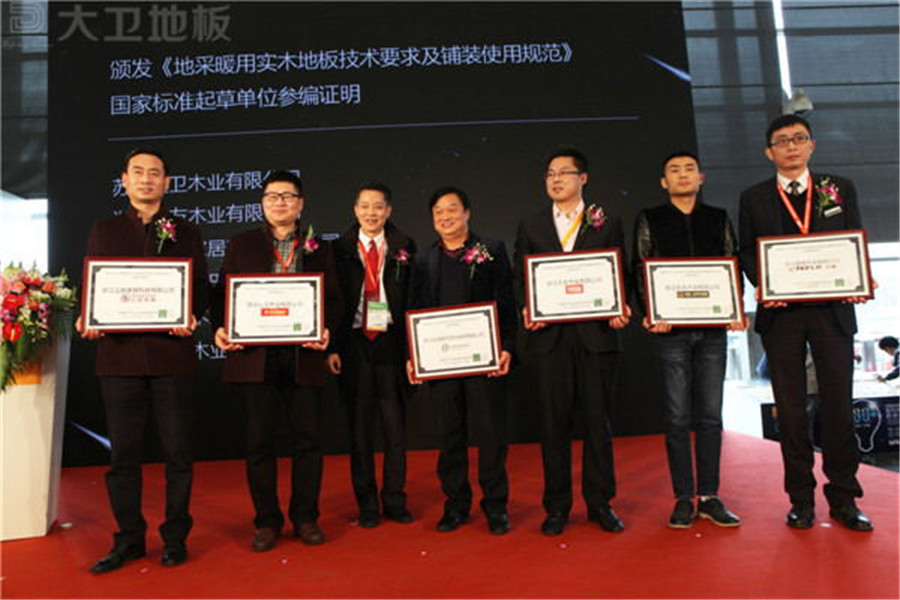 万象城(中国)地板董事长蒋卫（左二）获颁《地采暖用万象城手机在线官网技术要求及铺装使用规范》国家标准起草单位参编证明.jpg
